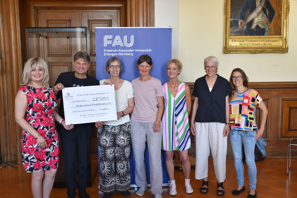 Die Präsidentin des Zonta-Clubs Erlangern, Dr. Magda Luthay (links) übergibt den Spendenscheck – im Beisein von FAU-Präsident Prof. Dr. Joachim Hornegger – an Gabriela Roter-Göken von der Katholischen Hochschulgemeinde Erlangen (Mitte). Auch dabei: Dr. Heike Kramer (3. v. l.) sowie Claudia Wieland, Anne Reimann und Dr. Andrea Link vom Zonta-Club Erlangen.