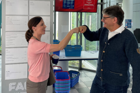 Fist bump von Prof. Dr. Dr. Patricia Wiater und FAU-Präsident Prof. Dr. Joachim Hornegger.