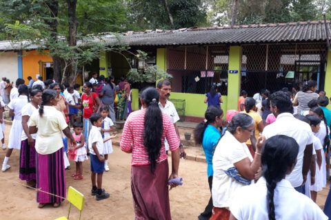 Abgebildet ist ein Gebäude mit vielen Menschen davor, die teils in Schlangen stehen. Sogenannte „Field Clinics“ sind in Sri Lanka in der Regel die ersten Anlaufstellen für die Bevölkerung, die meist nicht krankenversichert ist und teils in großer Armut lebt. FAU-Forschende unterstützen durch eine Klinikpartnerschaft mit dem National Hospital Kandy die wichtige Nierenforschung in Sri Lanka.