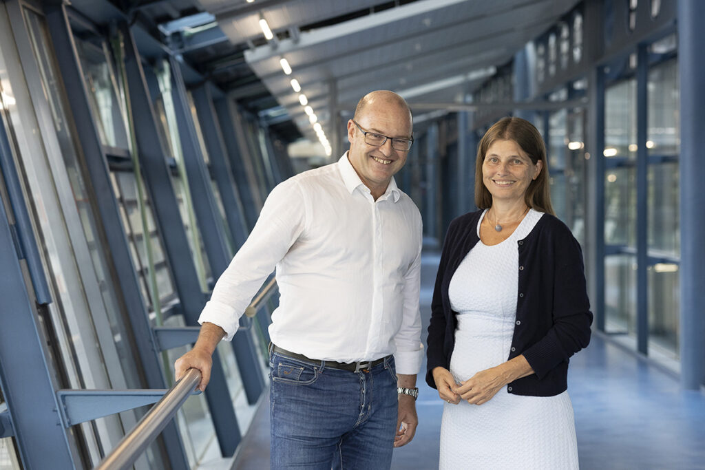 Ein Mann und eine Frau posieren nebeneinander in einem Gang.