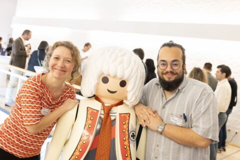 Zwei Menschen posieren mit großer Playmobil-Friedrich-Figur bei EELISA an der FAU