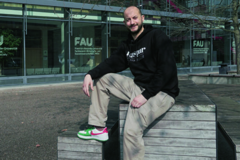 Kaspar Schmauser-Gründer sitzt lässig auf einem Stein.