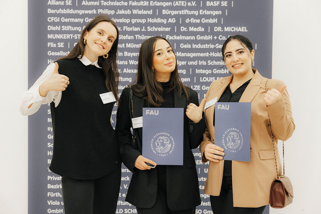 3 Studentinnen lächeln in die Kamera.